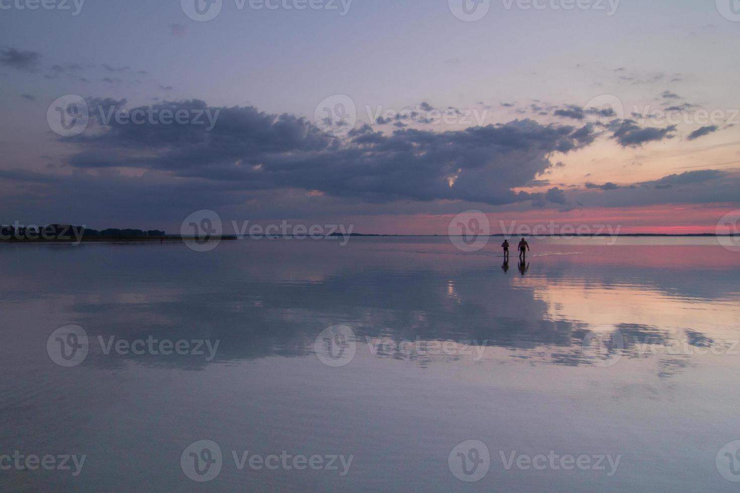 persone sagome a piedi attraverso acqua paesaggio foto