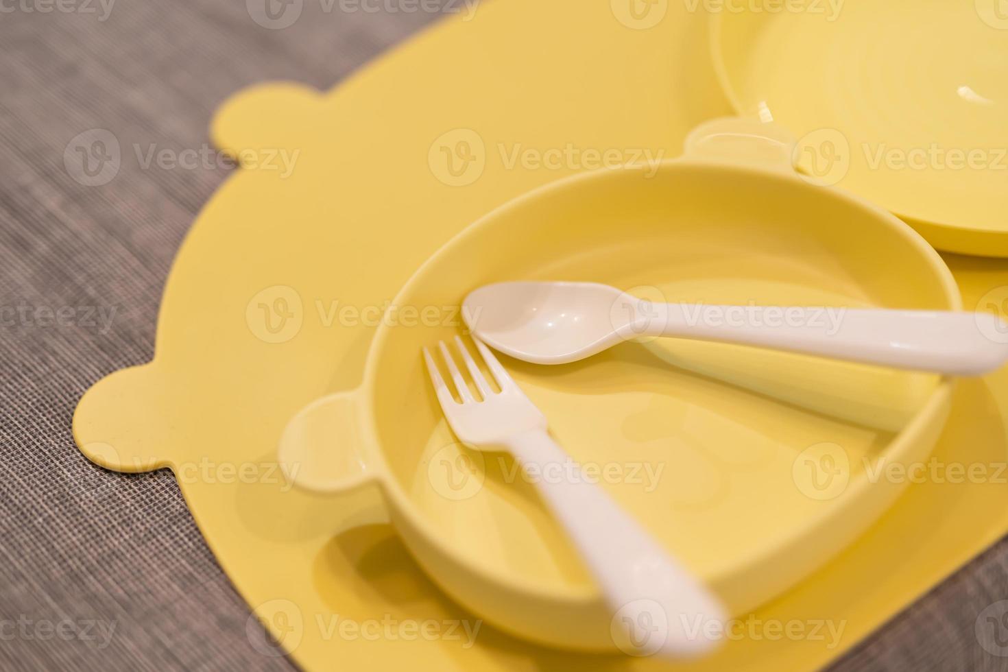 giallo alimentazione impostare. silicone bambino bavaglino, piatto, posate.  bambino piccolo se stesso alimentazione addestramento, bambino svezzamento  concetto. impostato di plastica piatto merce servendo bambino cibo.  19587827 Stock Photo su Vecteezy