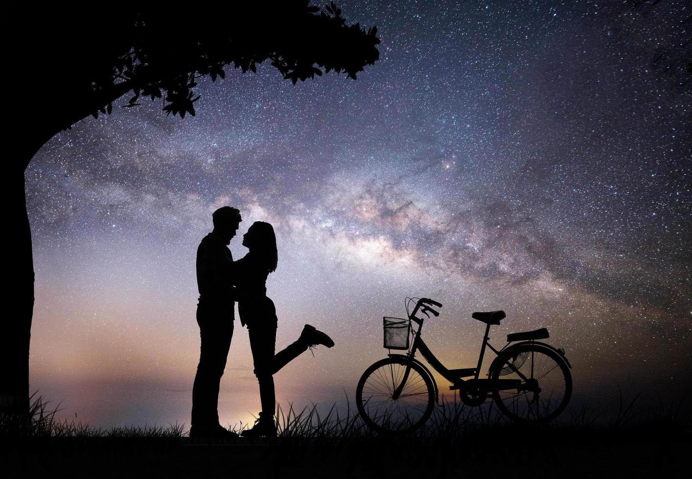 silhouette di una giovane coppia insieme durante la notte foto