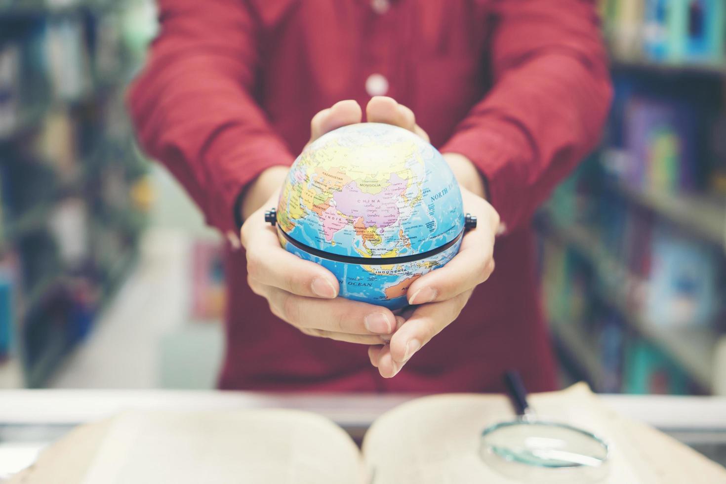 giovane studente tenendo in mano il modello di terra foto