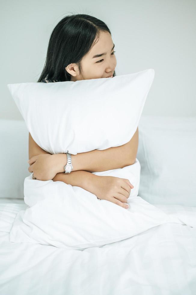 una donna seduta con un cuscino bianco foto