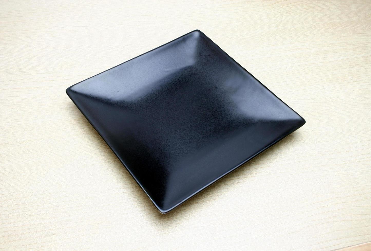 piatto quadrato nero sul tavolo foto