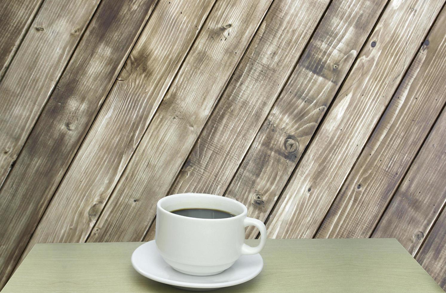 tazza di caffè contro il muro di legno foto