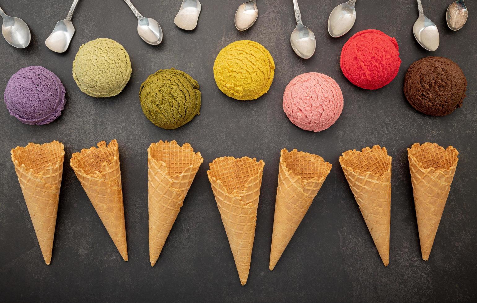 vari gusti di gelato in palline con cucchiai foto