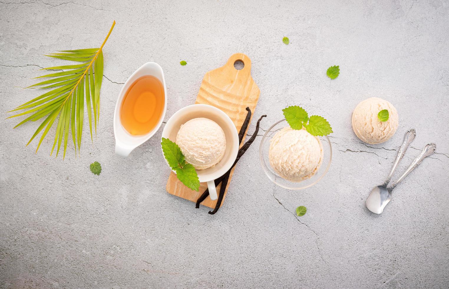 gusto gelato alla vaniglia in una ciotola con baccelli di vaniglia foto