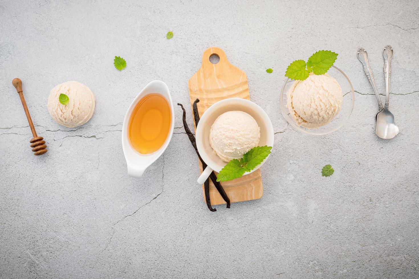 gusto gelato alla vaniglia in una ciotola con baccelli di vaniglia foto