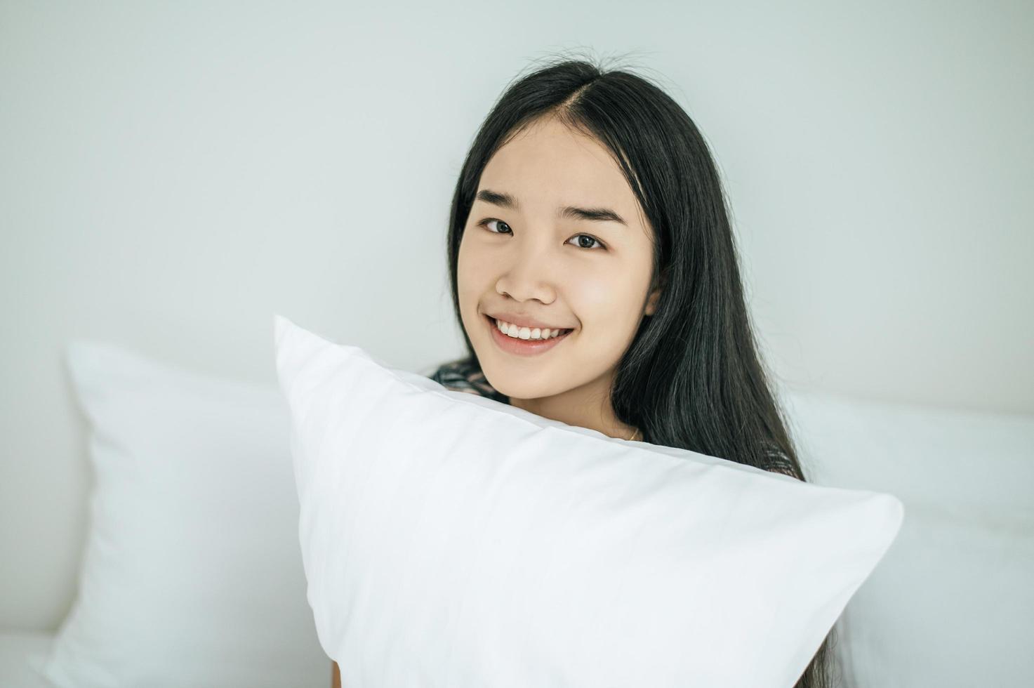 una donna seduta con un cuscino bianco foto