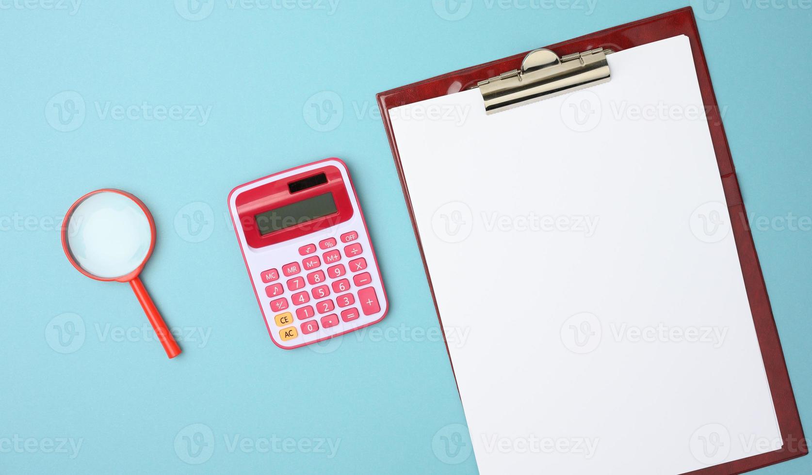 rosa calcolatrice, cartella con vuoto bianca lenzuola e nero lente d'ingrandimento su un' blu sfondo foto