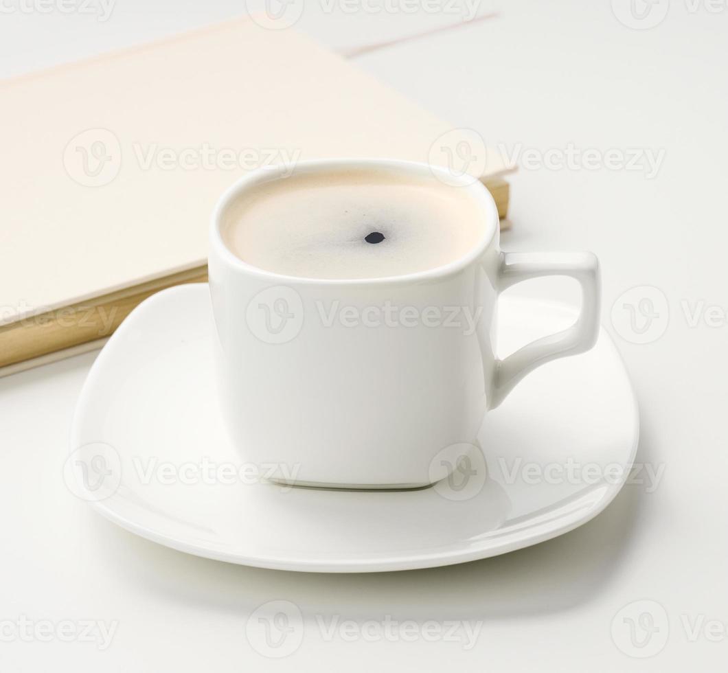 bianca ceramica tazza con nero caffè sta su un' bianca tavolo, superiore Visualizza, prima colazione foto