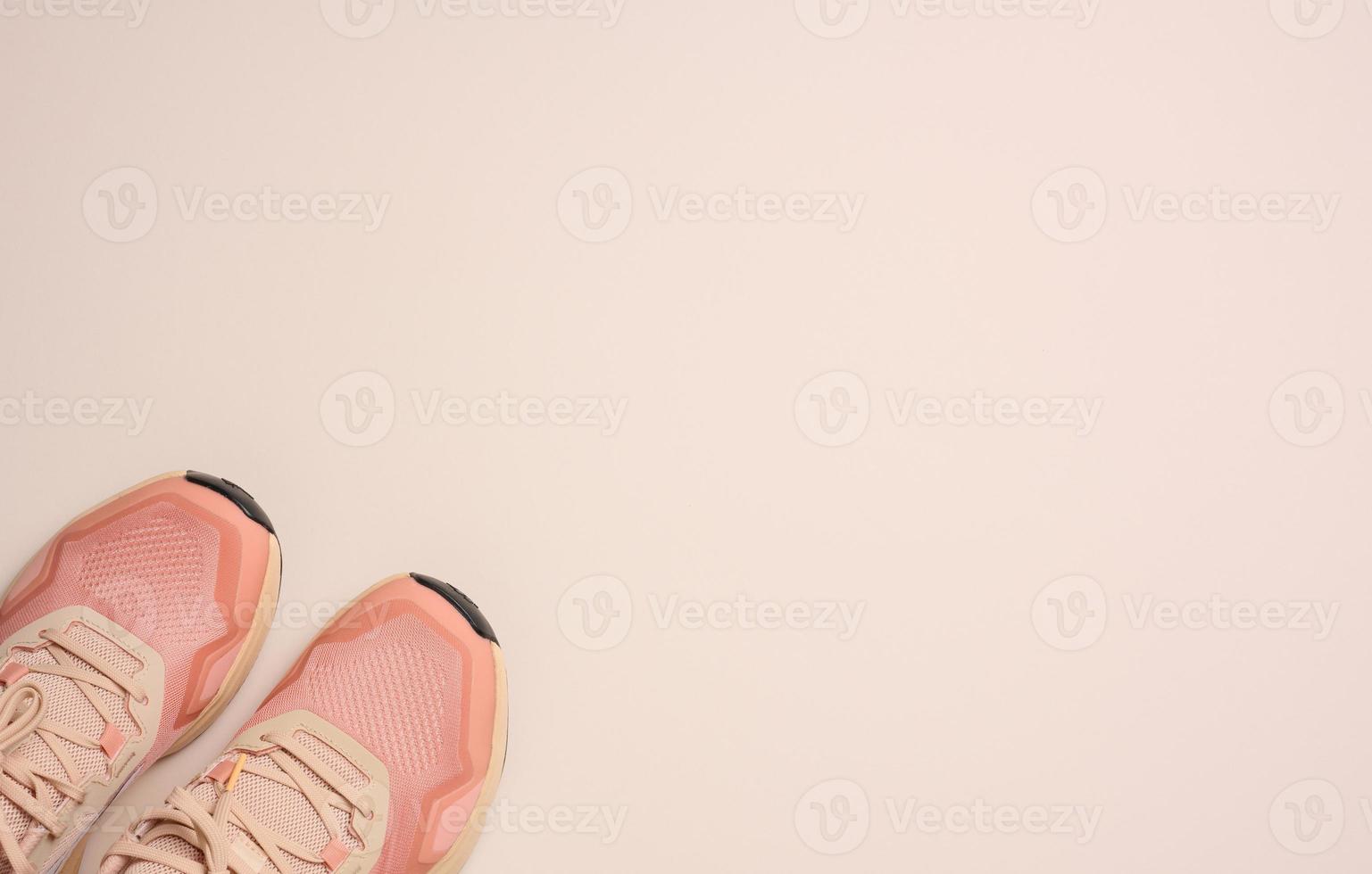 paio di rosa tessile scarpe da ginnastica su beige sfondo, superiore Visualizza foto