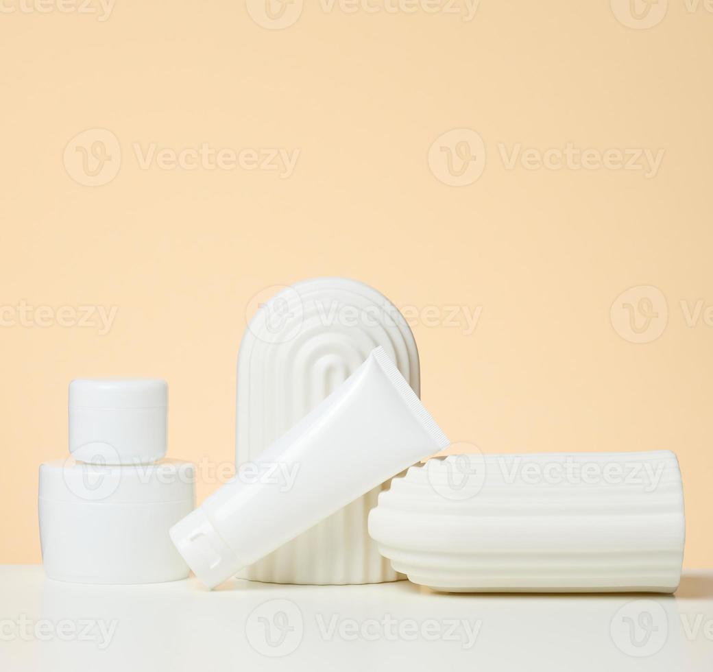 plastica bianca contenitore per cosmetici su un' bianca tavolo. vaso e tuba, Prodotto dimostrazione e promozione foto