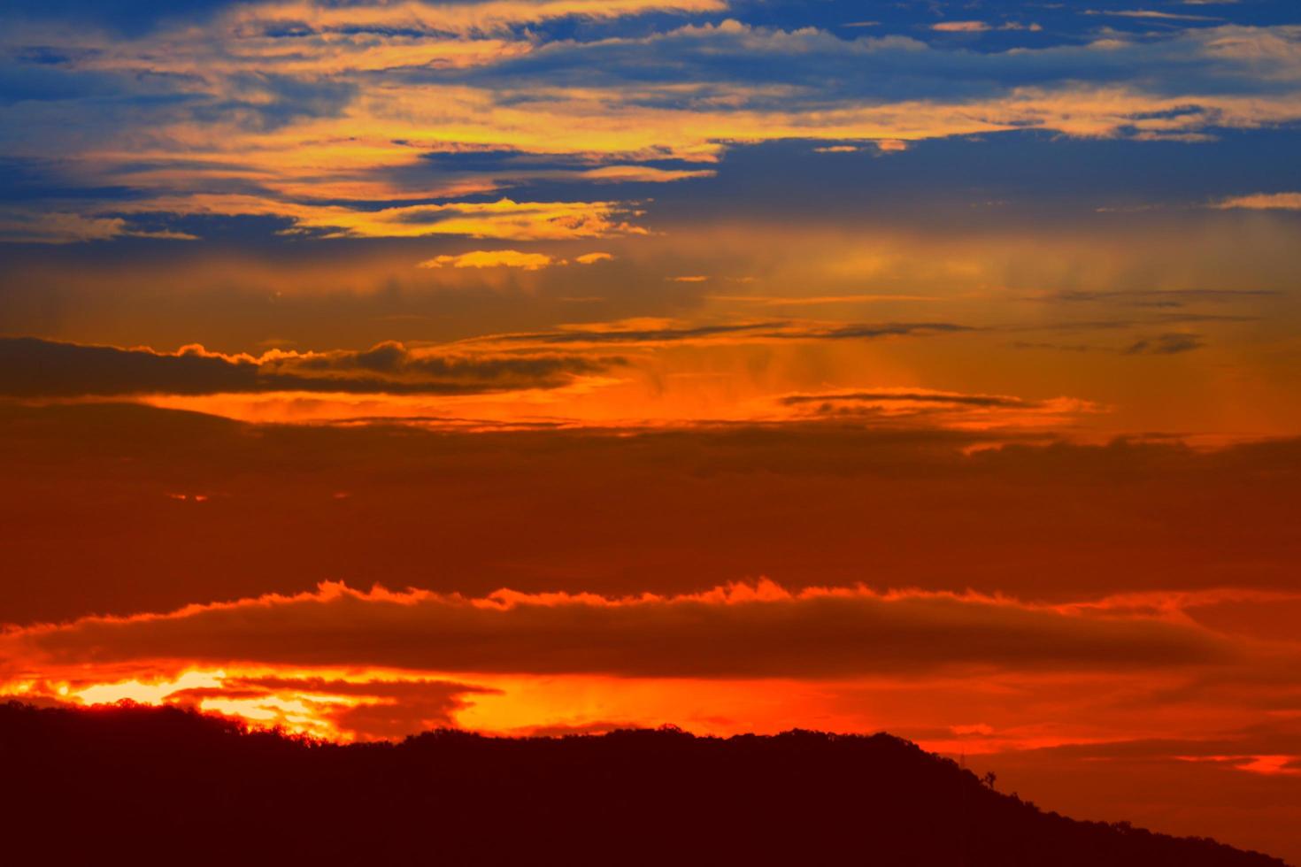 tramonto nel cielo e nube, bellissimo colorato crepuscolo tempo con montagna silhouette foto