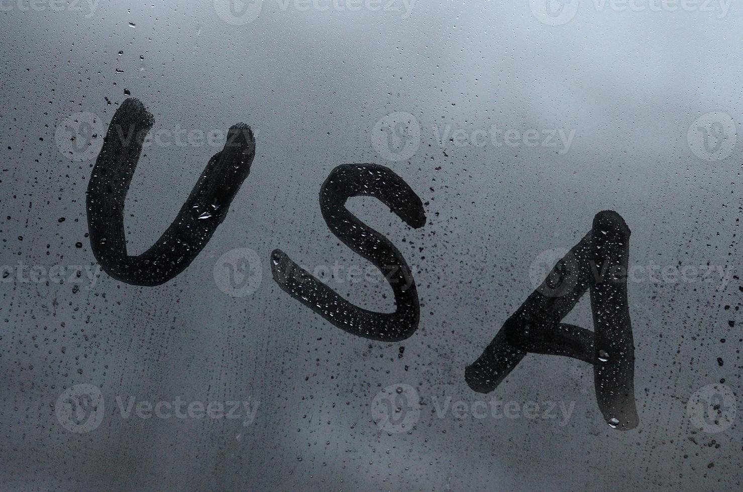 il inglese abbreviazione Stati Uniti d'America è scritto con un' dito su il superficie di il appannato bicchiere. unito stati di America foto