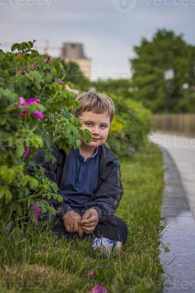 ritratto di un' bambino, un' ragazzo contro il sfondo di impianti nel un aria aperta parco. figli, viaggio. stile di vita nel il città. centro, strade. foto