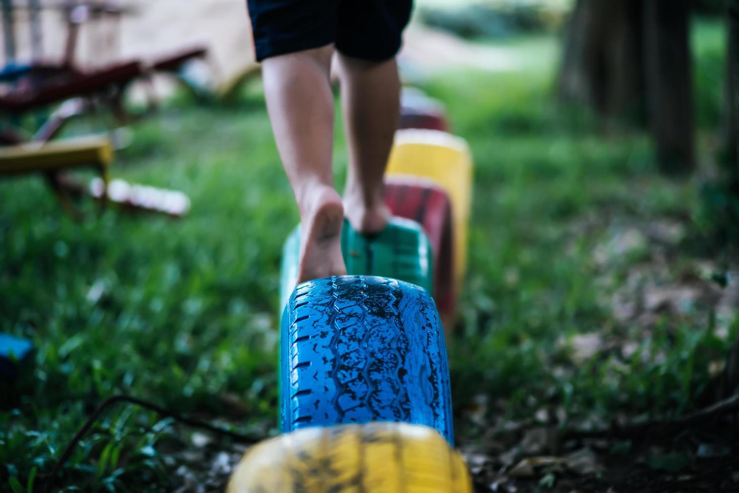 bambino che corre su pneumatici nel parco giochi foto