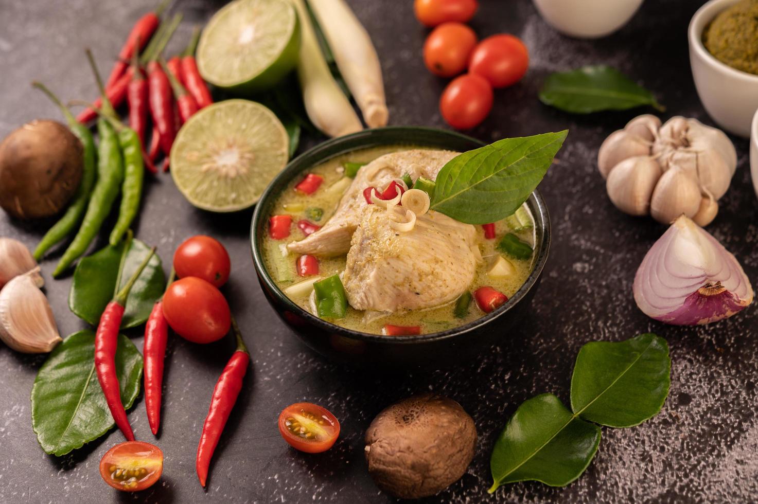 piatto di curry verde con pollo, peperoncino e basilico e pomodoro e lime foto