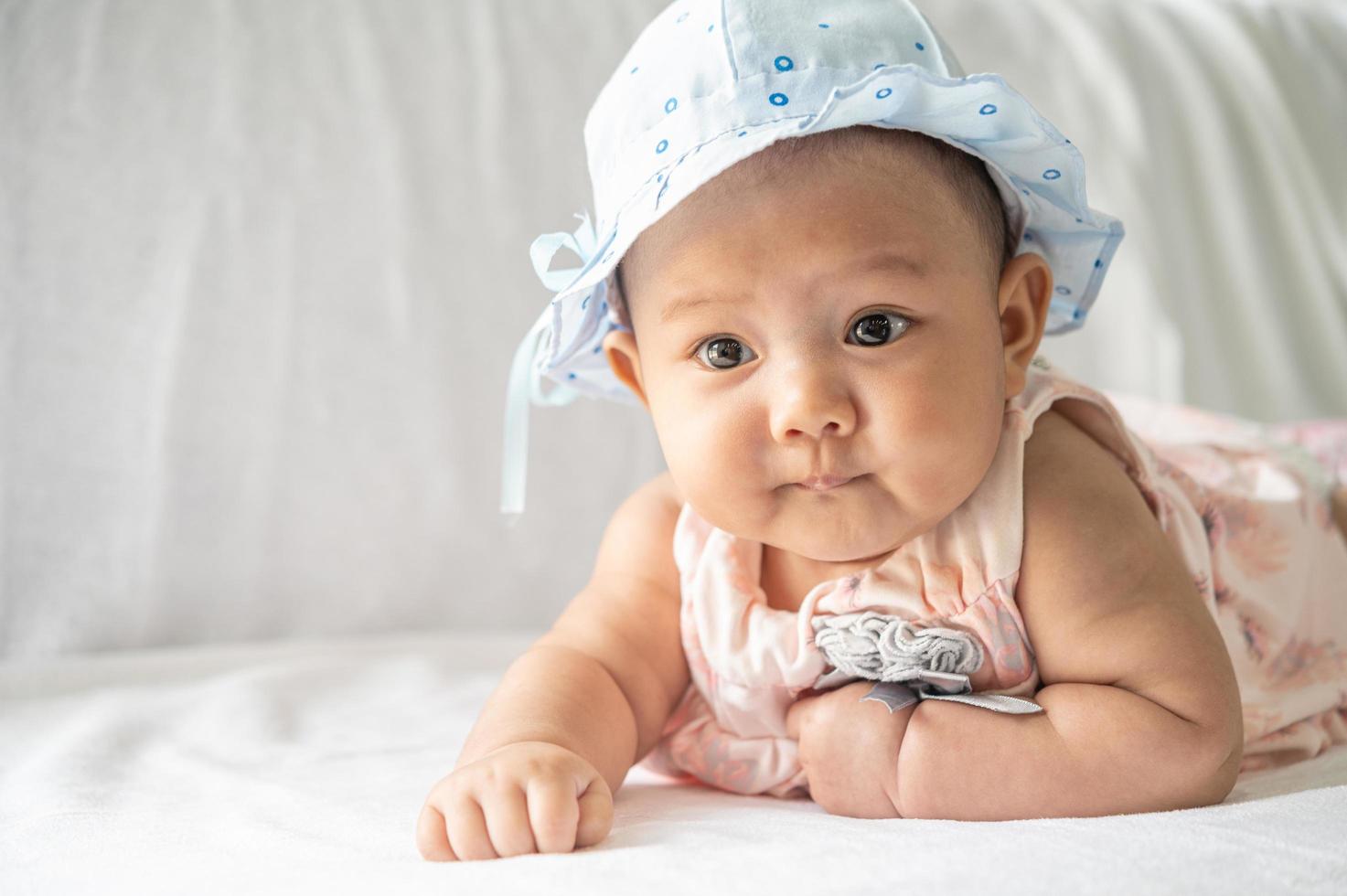 il bambino è sdraiato con la testa in alto sul letto foto