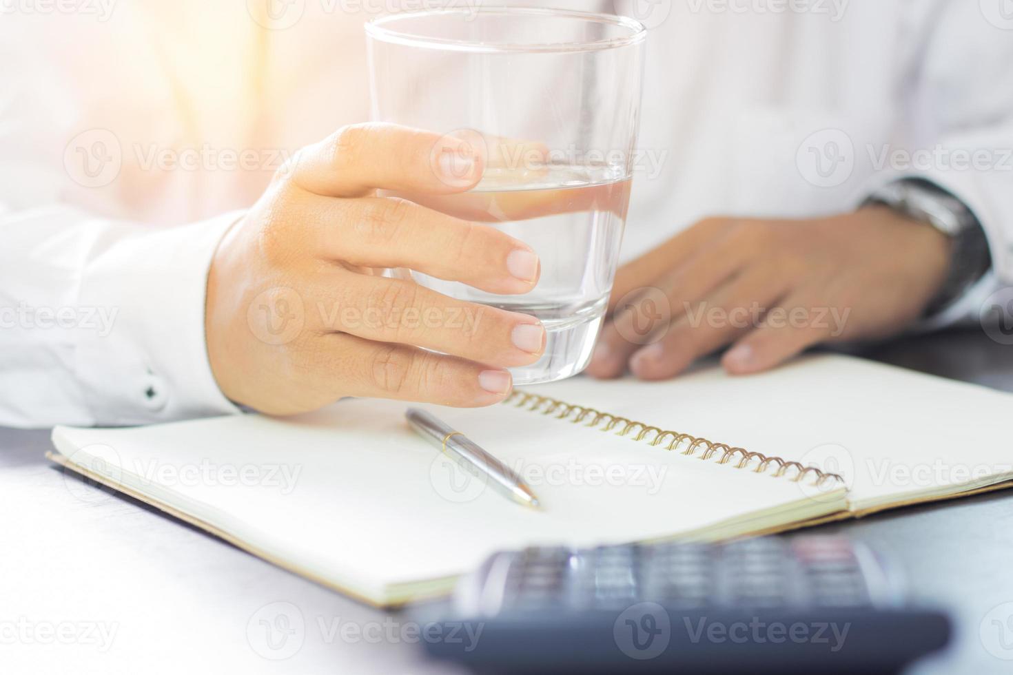 uomo d'affari tenendo un bicchiere di acqua potabile foto