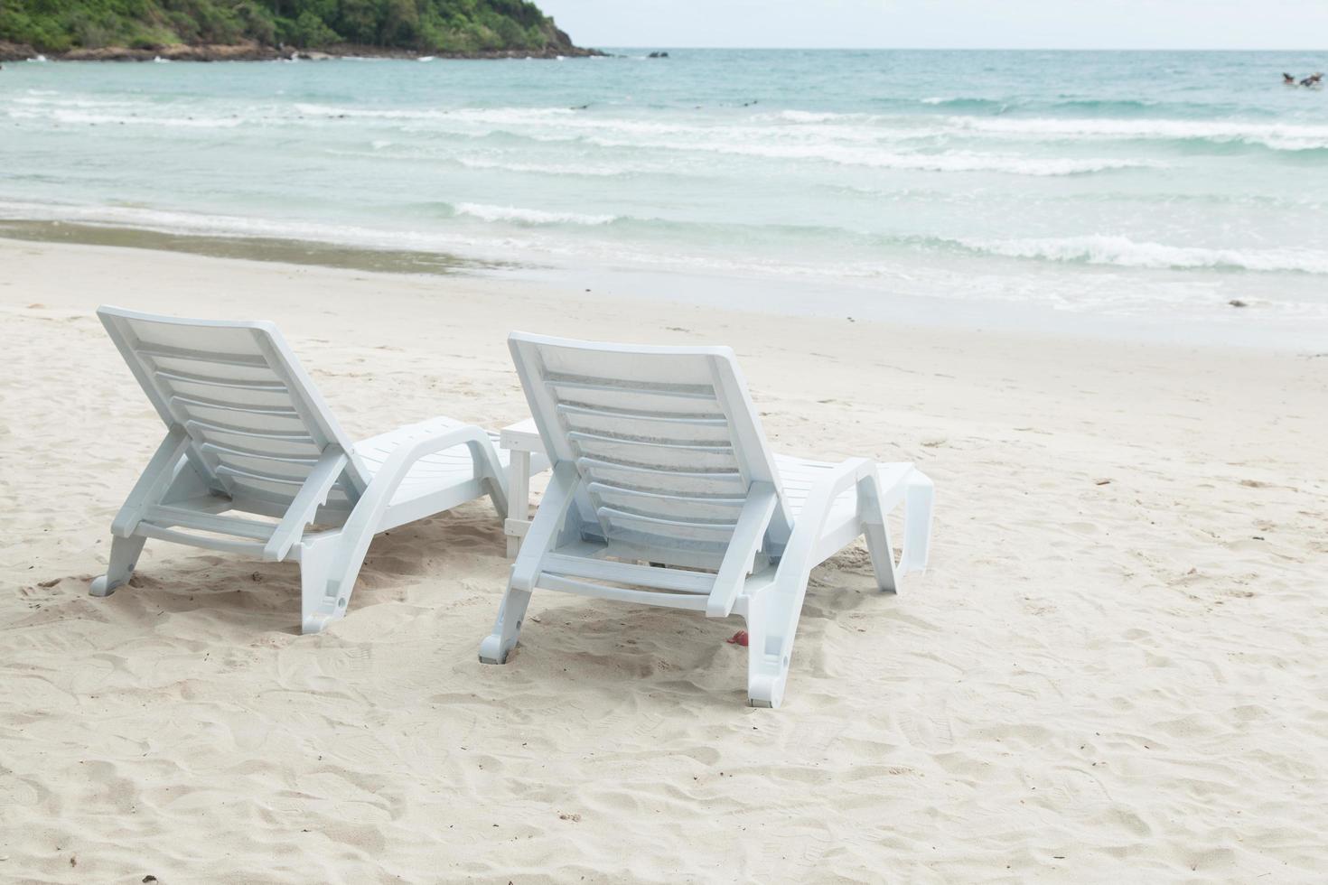 lettini prendisole bianchi sulla spiaggia foto