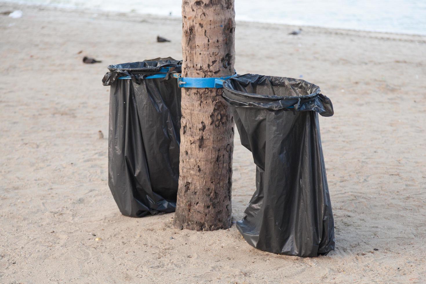 sacchi della spazzatura neri sulla spiaggia foto