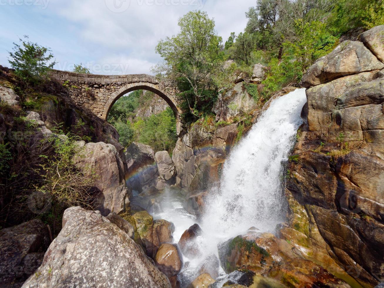 Ponte da misarela o ponte di mizarella nel montalegre, Portogallo con un' grande cascata Il prossimo per esso durante un' soleggiato giorno. rurale viaggio e vacanze nel natura. foto