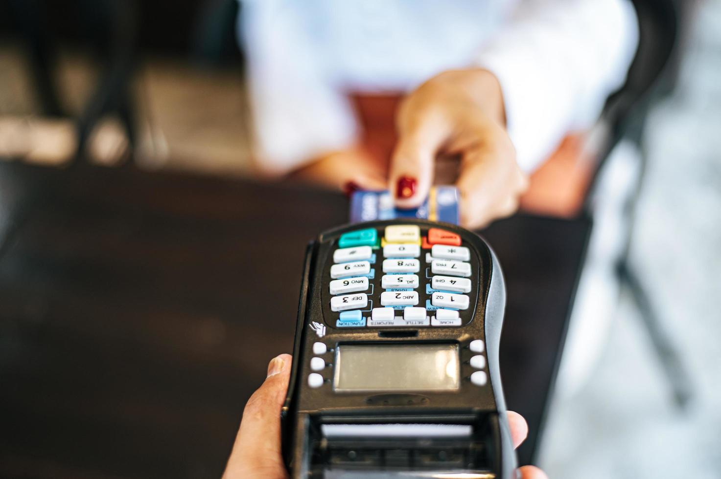 primo piano della donna che paga con carta di credito nella caffetteria foto