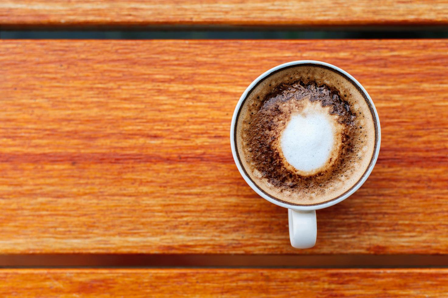 vista dall'alto della tazza di caffè sul fondo della tavola in legno foto