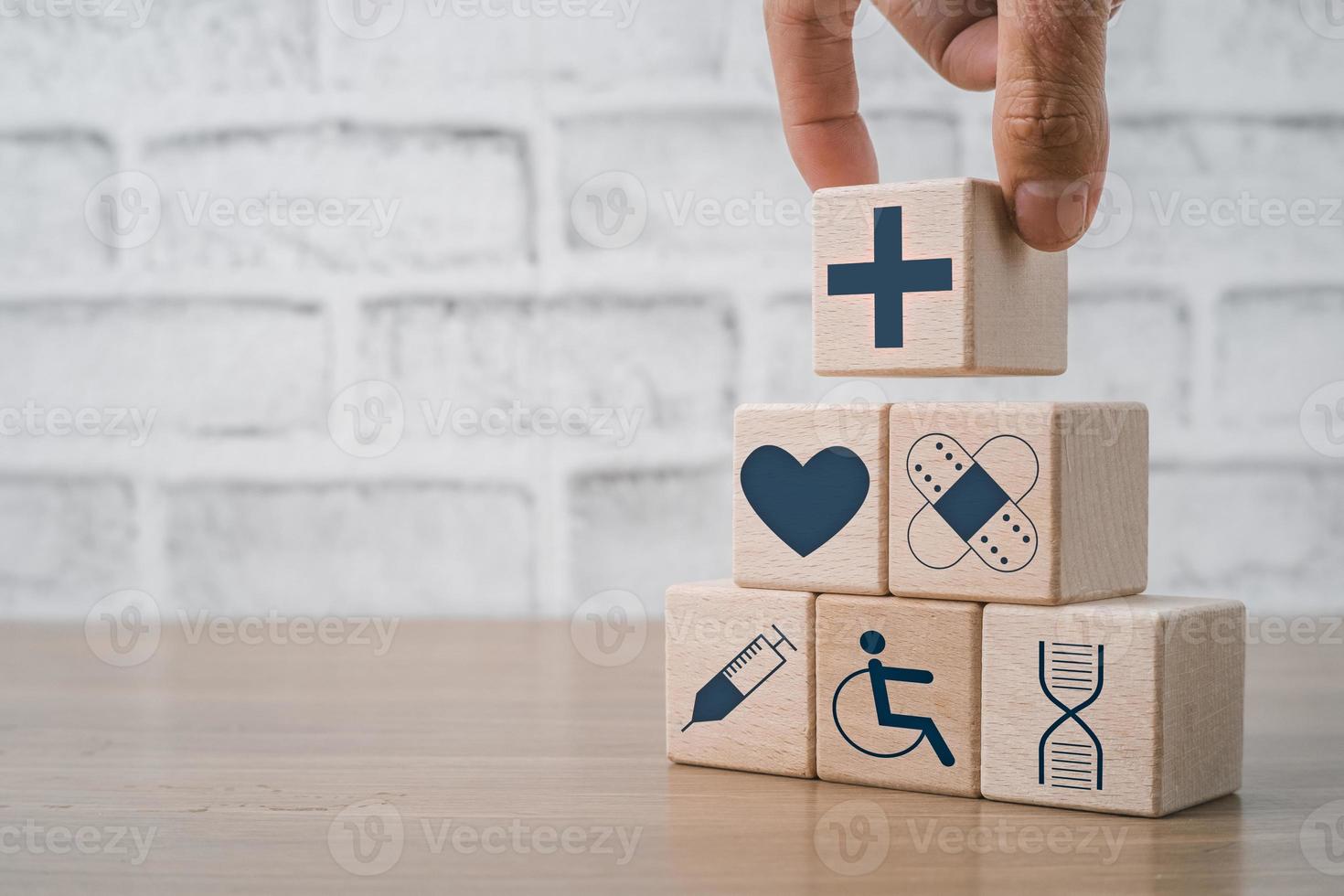 mano Tenere di legno bloccare con icona assistenza sanitaria medico con copia spazio, concetto di assicurazione per il tuo Salute, Salute cura, mondo Salute giorno. foto