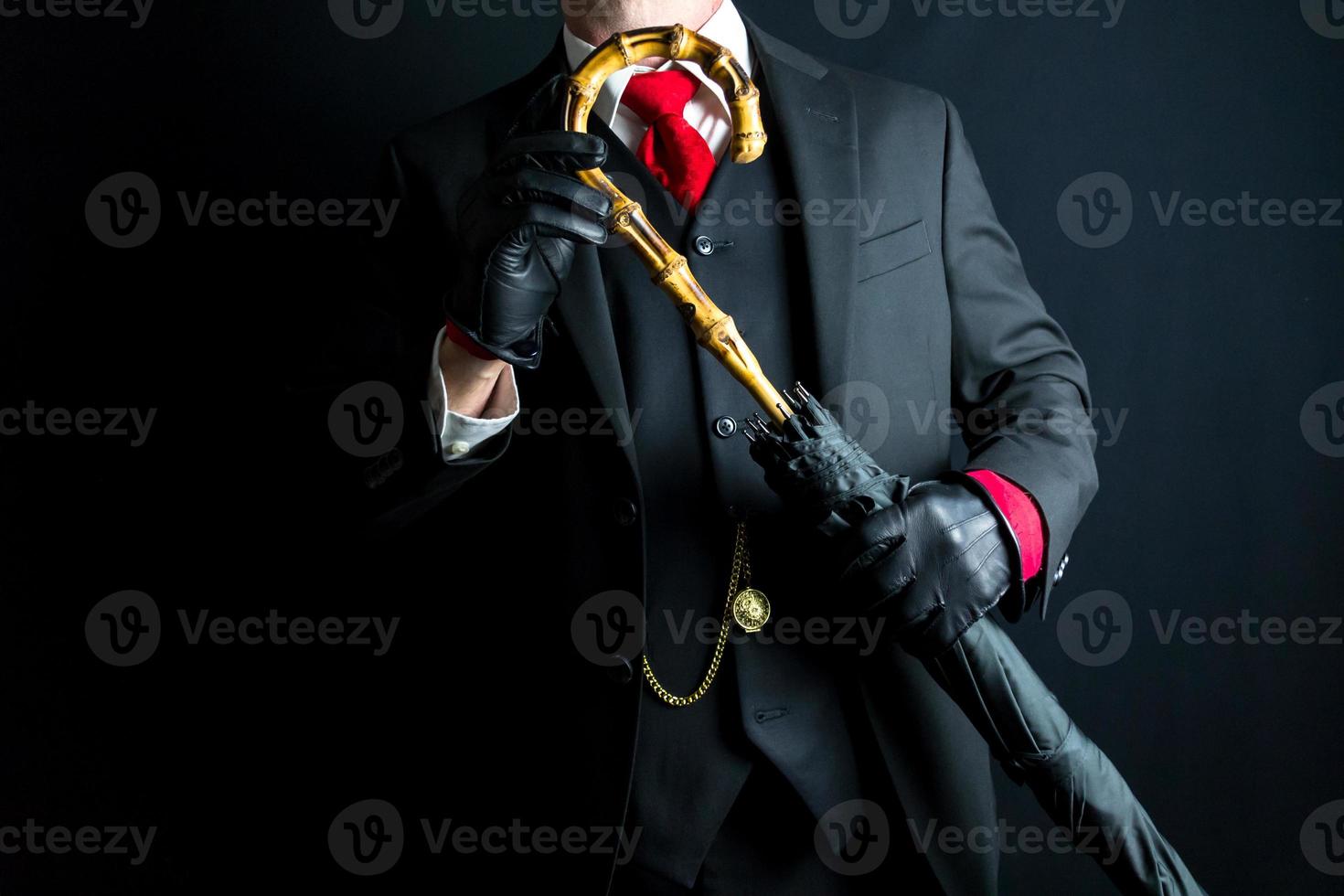 ritratto di signore nel nero completo da uomo e rosso cravatta Tenere ombrello su nero sfondo. retrò moda e Vintage ▾ stile. foto