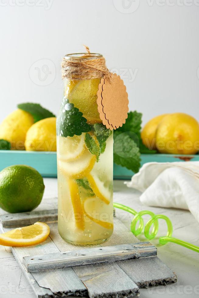 morbido bevanda limonata nel un' bicchiere bottiglia e maturo fresco limoni foto