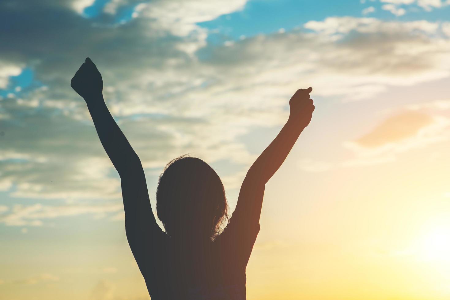 silhouette di bambina alzando le mani per la libertà foto