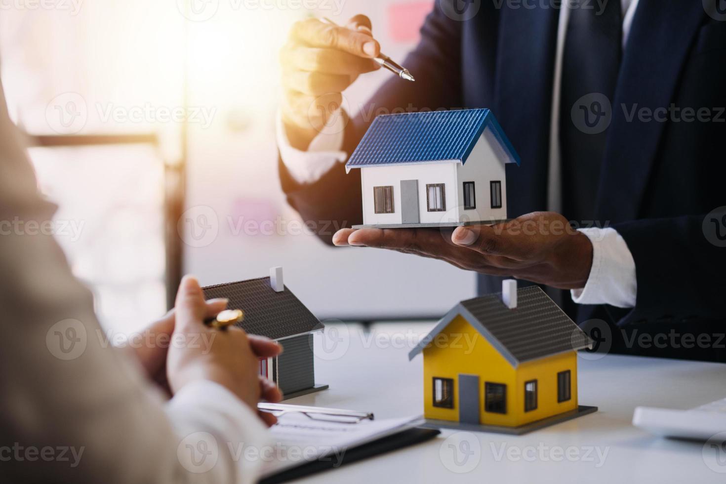 l'agente di intermediazione immobiliare consegna un campione di una casa modello al cliente, contratto di mutuo ipotecario che fa leasing e acquista e vende casa e contratto di assicurazione sulla casa concetto di mutuo ipotecario foto