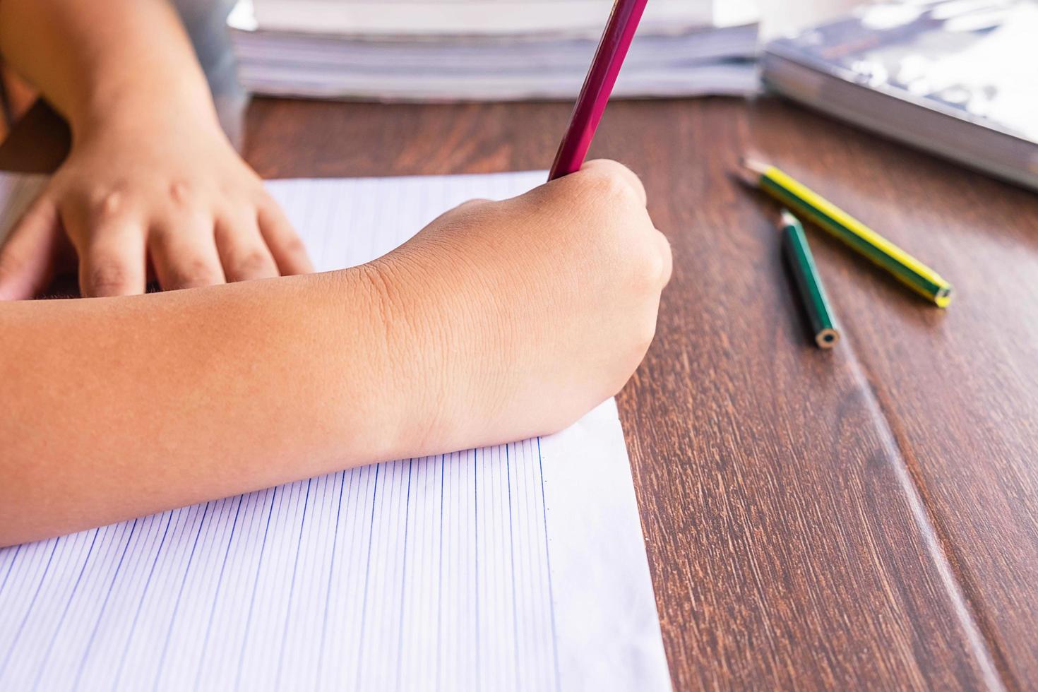 bambino che scrive in un taccuino foto