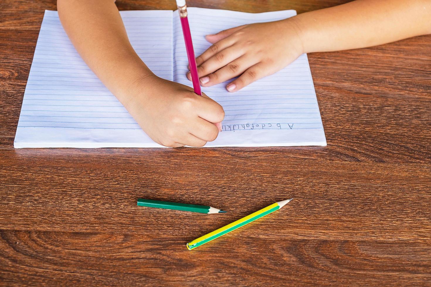 bambino che scrive in un taccuino foto