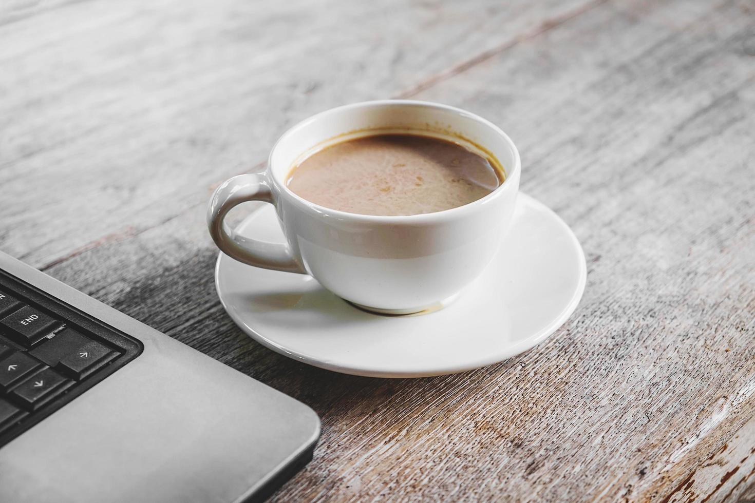 tazza di caffè e un computer portatile foto