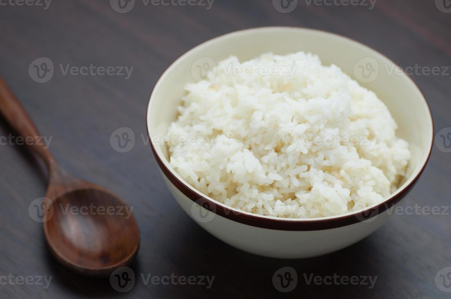 riso tailandese in una ciotola con un cucchiaio di legno sul tavolo foto