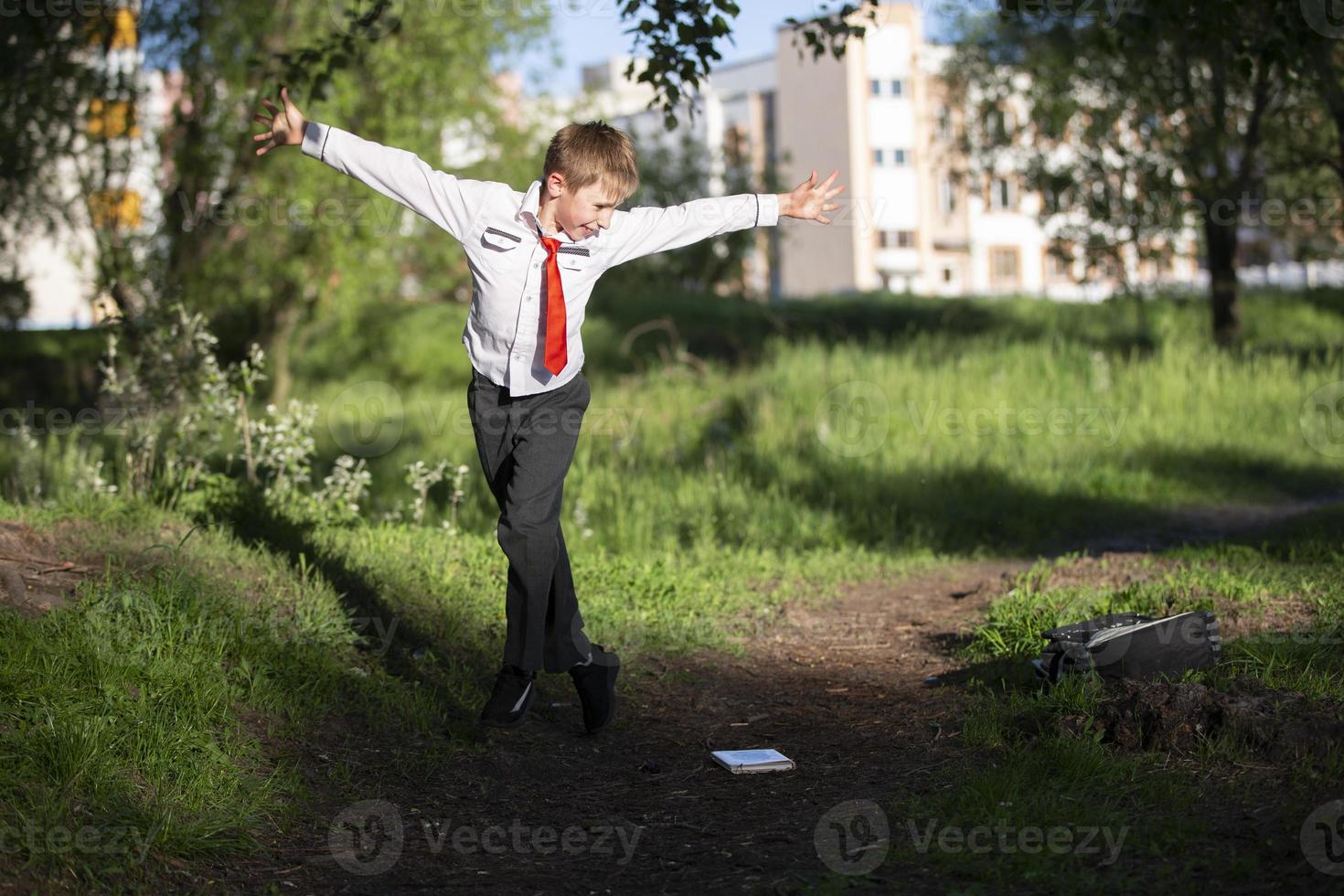 un' contento scolaro lanci su il suo scuola zaino e gioisce a il inizio di il vacanze. il fine di il scuola anno e il inizio di il vacanze. foto