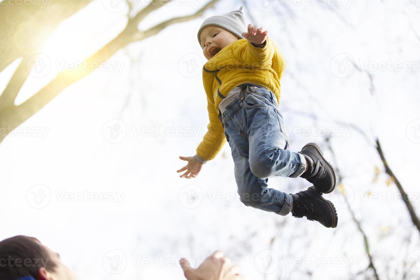 un' giovane contento padre lanci su il suo poco figlio. foto