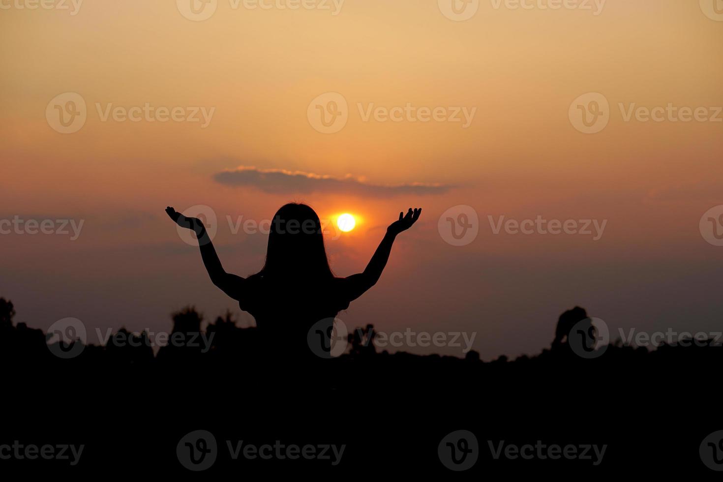 silhouette di umano mano sollevato per rendere un' desiderio, tramonto sfondo foto