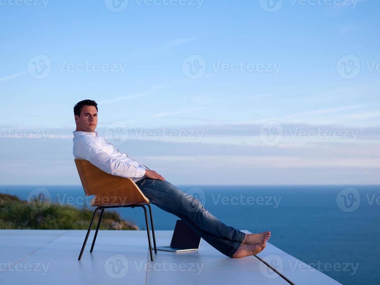 rilassato giovane uomo a casa su balcone foto