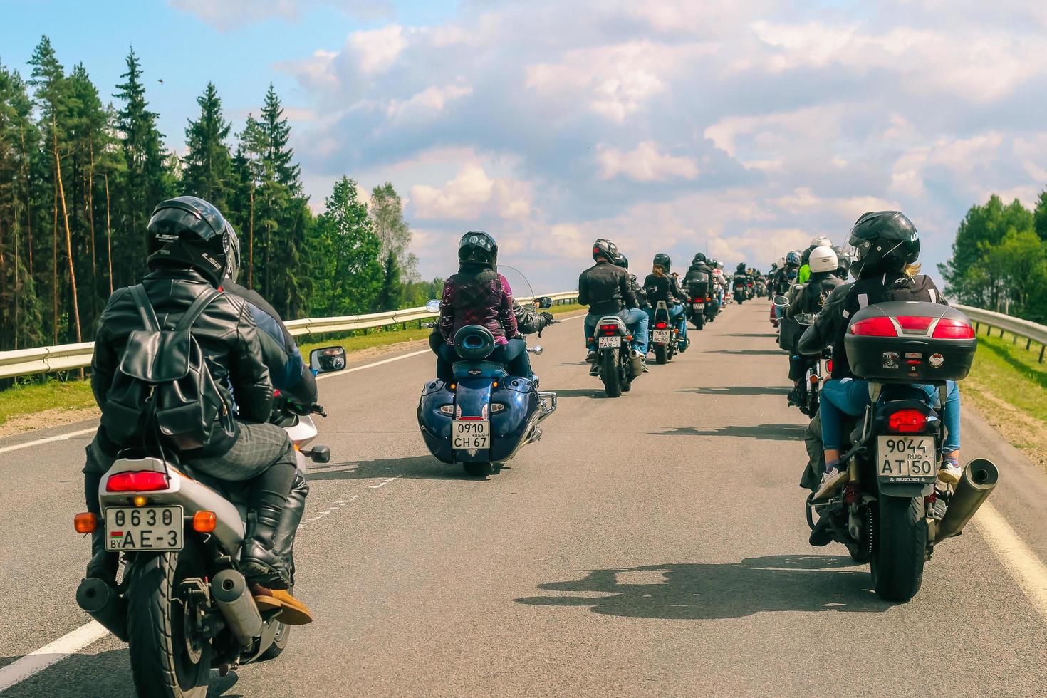gruppo di motociclisti cavalcate su asfalto nazione strada su estate soleggiato giorno. parata di motociclette. foto