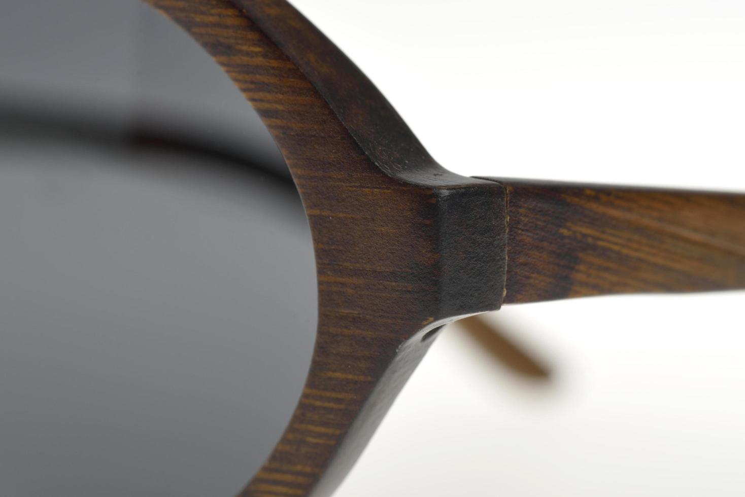 primo piano di una cornice in legno scuro di occhiali da sole foto