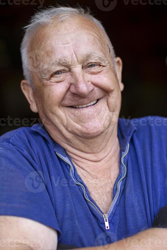 ritratto di un anziano dai capelli grigi uomo, lui sembra a il telecamera e sorrisi. foto