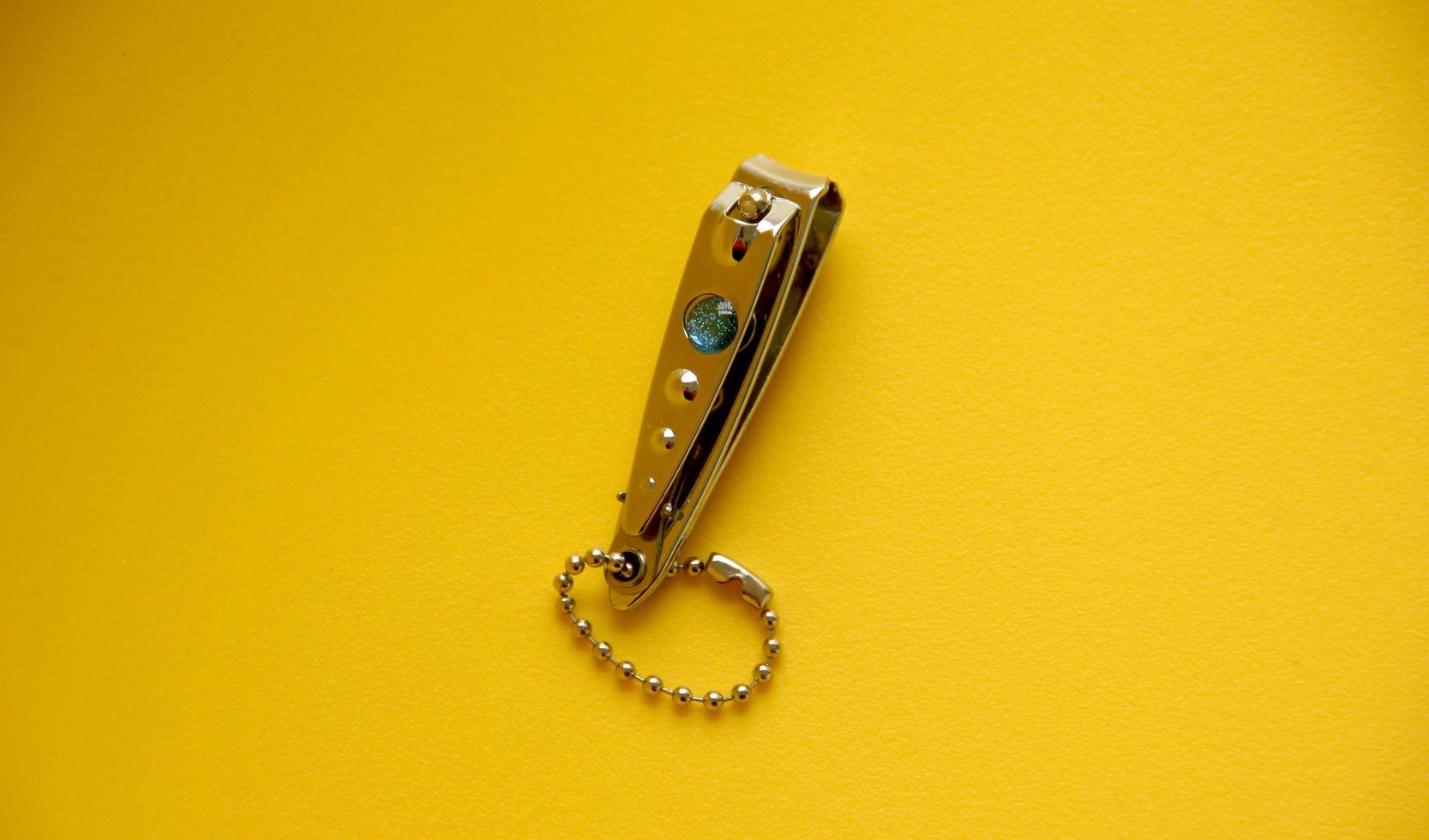 piccolo mini argento inossidabile acciaio chiodo clippers con catena. facile per trasportare chiodo Prodotto foto isolato su giallo sfondo.