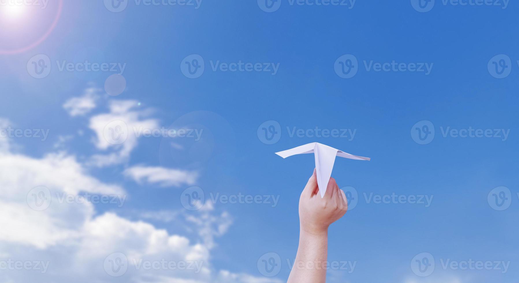 ragazzo mano Tenere un' carta aereo il sfondo è un' bellissimo cielo. foto