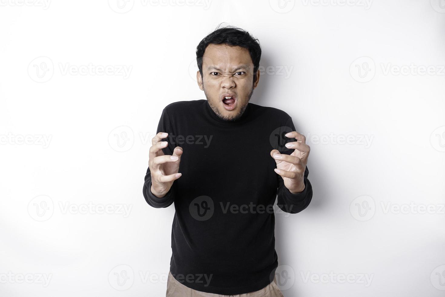 il arrabbiato e pazzo viso di asiatico uomo nel nero camicia isolato bianca sfondo. foto