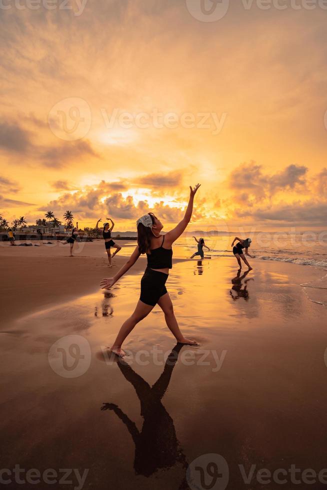 un' gruppo di asiatico donne danza insieme e pieno di gioia su il spiaggia foto