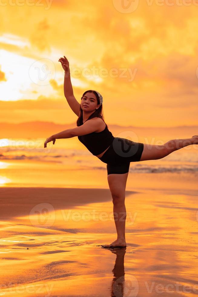 un asiatico adolescente danza balletto nel nero per un' Festival di il spiaggia foto