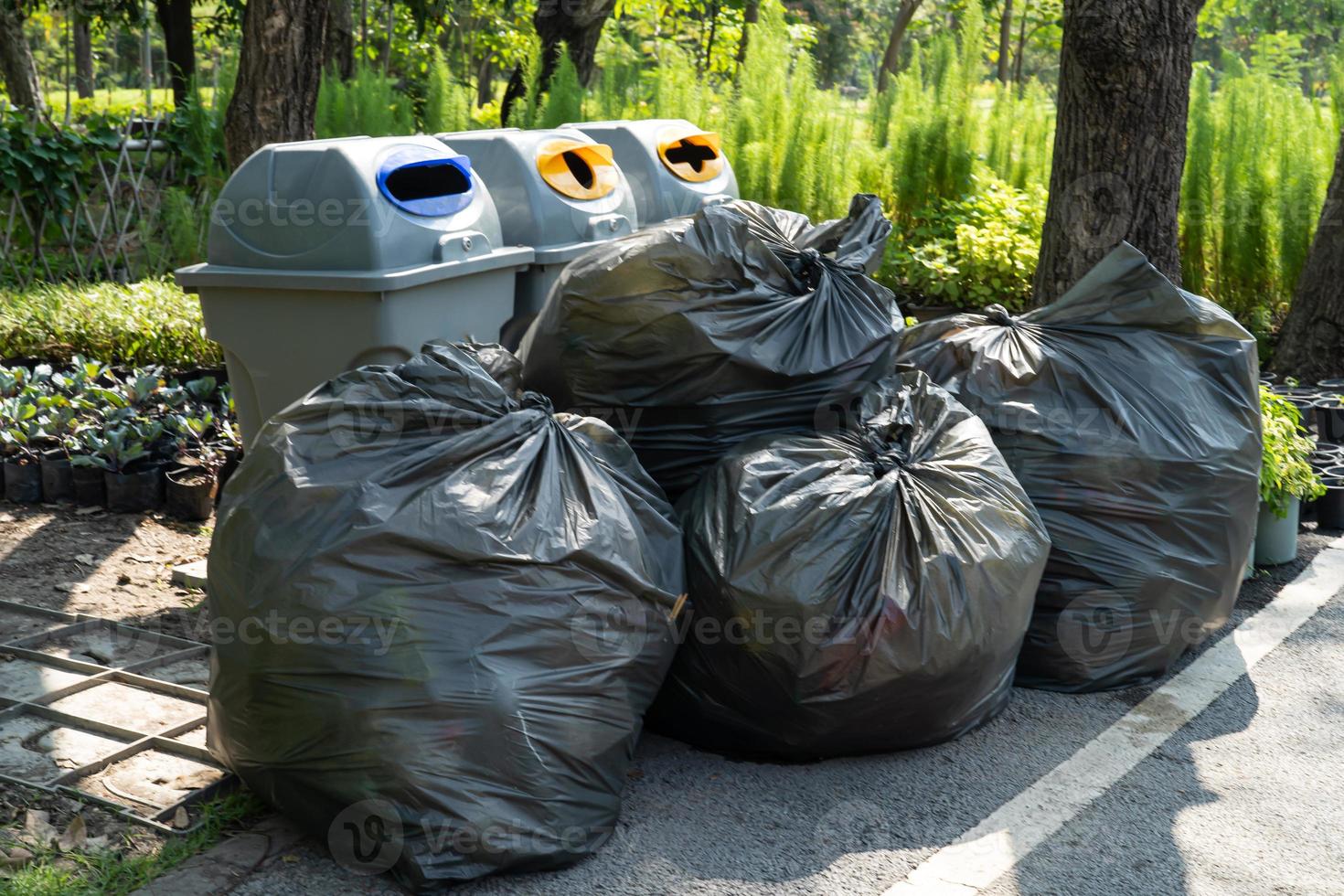 sacchetti di spazzatura in plastica nera di spazzatura sul marciapiede, concetto di ambiente pulito. foto