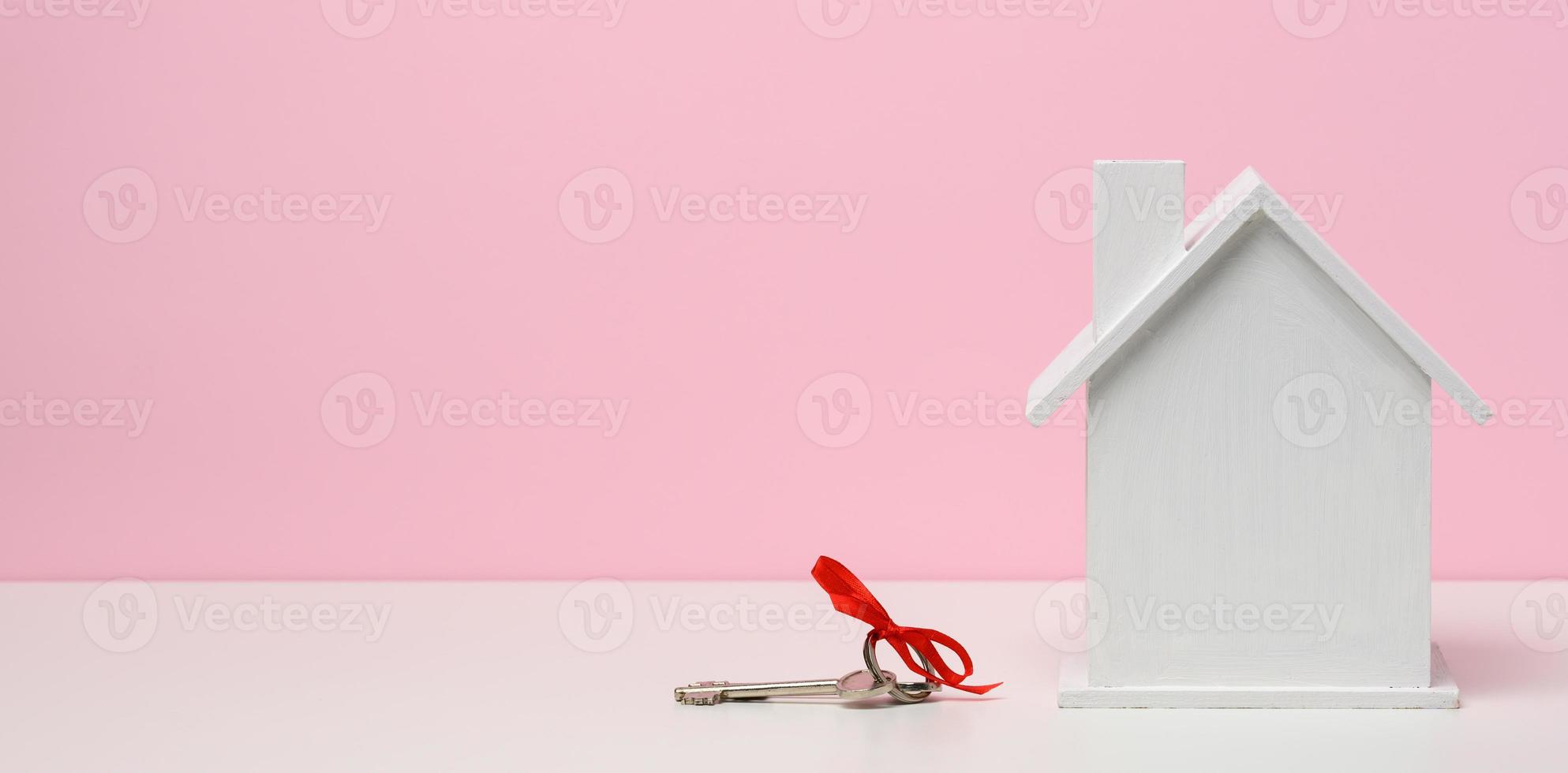 di legno Casa su un' rosa sfondo. vero tenuta noleggio, Acquista e vendita concetto. agente immobiliare Servizi, edificio riparazione e Manutenzione, foto